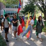 International students lead the Fall 2023 convocation parade, their country’s flag in hand.